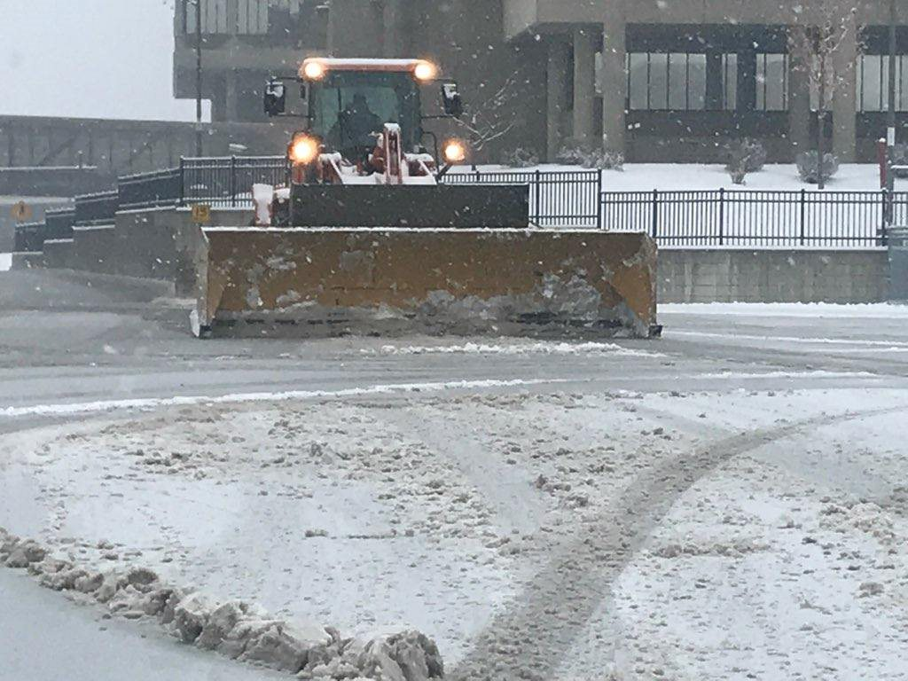 Guy using machinery to plow ice and snow