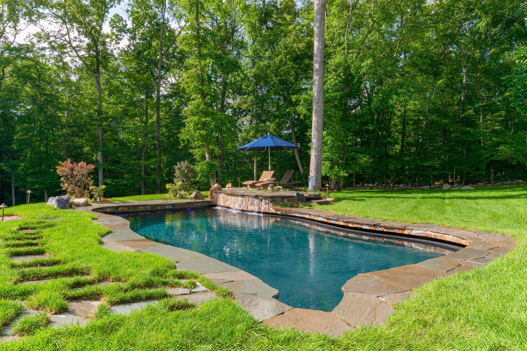 Artfully designed pool with lush landscaping