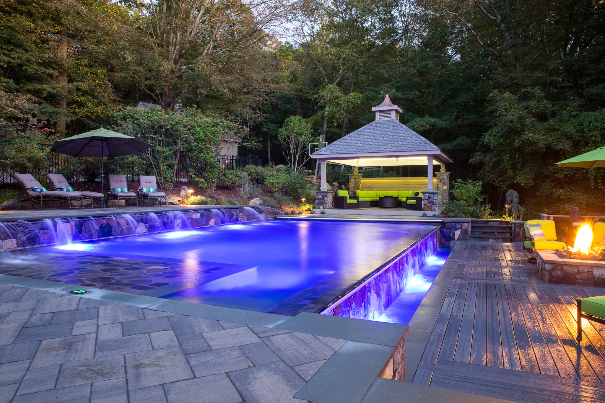 Extravagant pool boasting stone wall and elegant deck