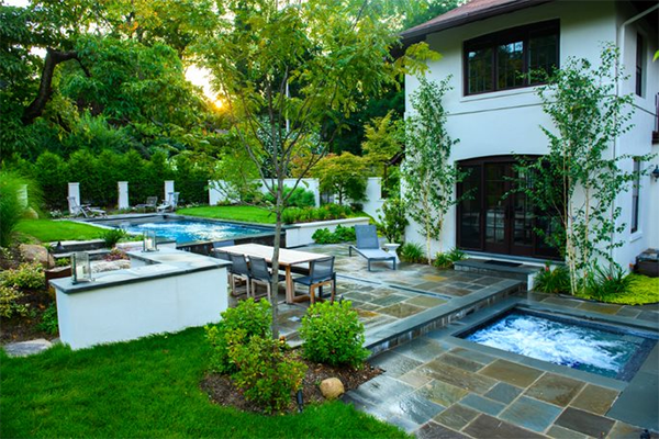 Outdoor pool surrounded by elegant landscape concept image for benefits of professional landscape design
