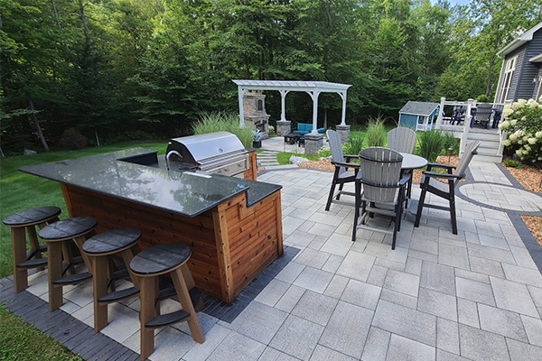 Patio with a bbq area and bar stools for guests