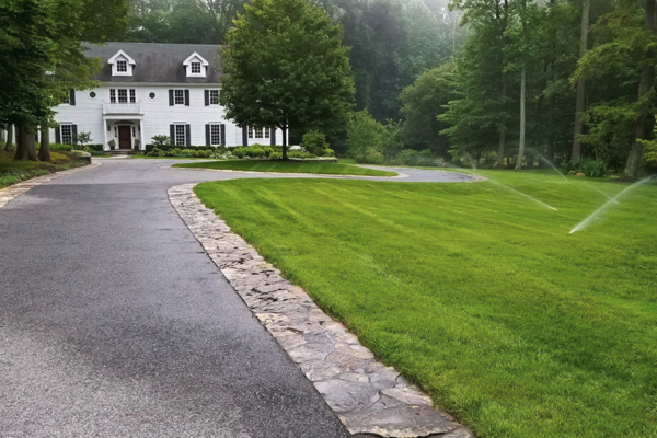 Vibrant, lush green lawn with strategically placed sprinklers irrigating the grass for sustainable landscape maintenance