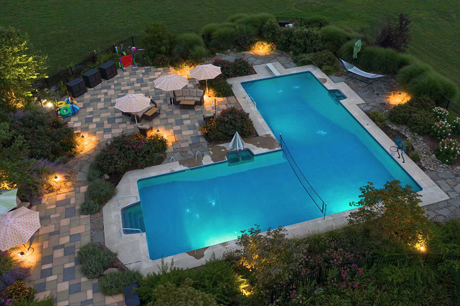 L-shaped Pool with mesmerizing lighting features and stunning landscape illumination