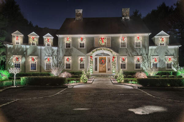 A charming house aglow with custom Christmas decorations, highlighting the magic of holiday decorating services in New York.