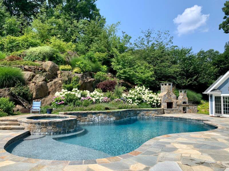 stunning luxury pool created by Land of ELITE using luxury pool features like a swim up bar and rock features