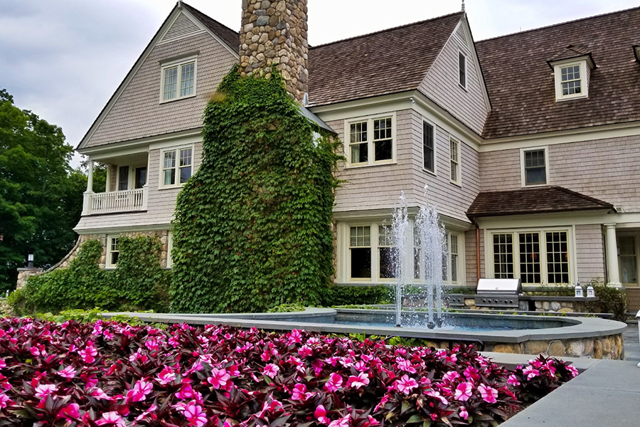 Charming home with a beautifully landscaped garden and water fountain, highlighting elegant landscape architecture