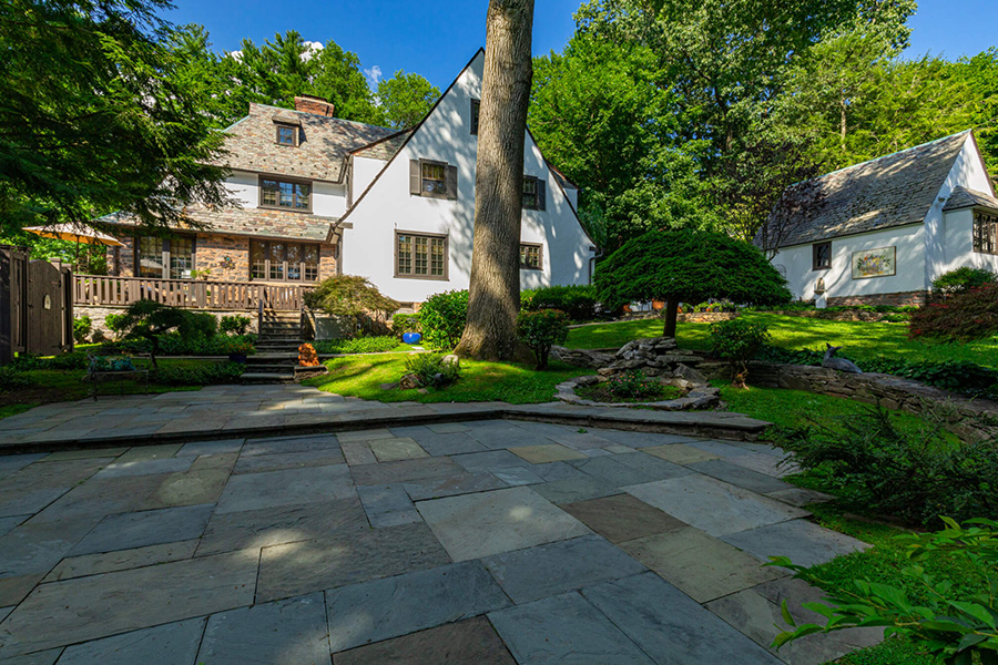 Elegant backyard patio with stone hardscaping, providing a stylish and durable outdoor living area for gatherings