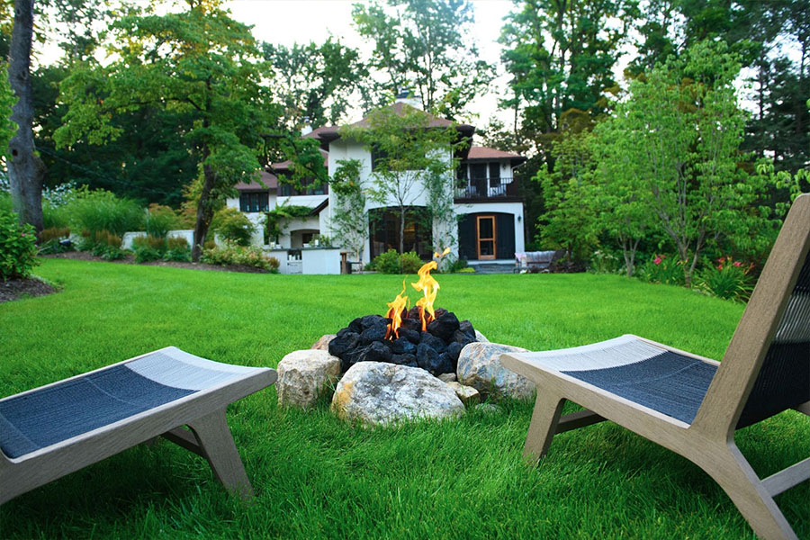 Outdoor seating with a cozy firepit, ideal for relaxation, showcasing expert landscape design and serene ambiance